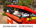 Small photo of Woodbridge Suffolk UK April 20 2022: A public wheelie bin that is overflowing with recycling that hasnâ€™t been collected and is causing a public nuisance