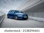 Small photo of Kyiv, Ukraine - April 03 2016: blue mk7 Volkswagen Golf R on a ramp front of cloudy sky. Three quarter perspective view