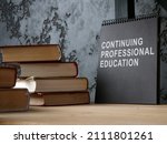 Small photo of Continuing professional education on the black notepad and books.