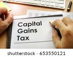 Small photo of Hands holding documents with title capital gains tax CGT.