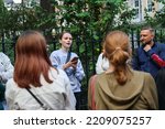Small photo of 28 6 2022 Young lady gives a speech to group of people or preach to strangers the Christian faith in street in Soho Square, London