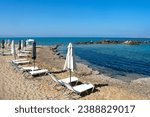 Small photo of Beautiful Crete island, Greece. Charming coastal village of Kokkini Hani. Popular tourist destination with sandy beaches and a quiet laid back atmosphere. Sun beds by the blue Aegean sea.