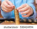 Small photo of Child amassed a large pile of gold coins, close-up