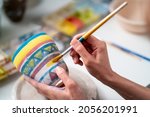 Small photo of Asian woman learning color painting her self-made pottery at home. Confidence female enjoy hobbies and indoors leisure activity handicraft ceramic sculpture and painting workshop at pottery studio.