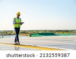 Small photo of Professional man engineer using tablet maintaining solar cell panels on building rooftop. Technician working outdoor on ecological solar farm construction. Renewable clean energy technology concept