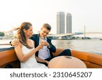 Caucasian couple relax and enjoy urban outdoor lifestyle travel city on luxury private boat yacht sailing in the river with celebrating holiday event drinking champagne together on summer vacation.