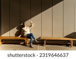 Happy Asian woman sitting on outdoor bench during shopping at Tokyo city, Japan. Attractive girl enjoy and fun urban outdoor lifestyle travel city street in autumn holiday vacation.