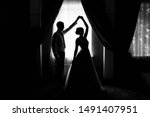 Small photo of Bride and groom at the window. Silhouette of the bride and groom at the window. Silhouette of newlyweds. Newlyweds at the window. Dance of the newlyweds. The bride and groom waltz. Wedding dance