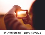 New year planning and vision concept, Close up of woman hands making frame gesture with sunset, Female capturing the sunrise. copy space.
