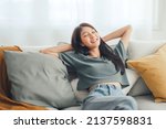 Small photo of Relaxed young asian woman enjoying rest on comfortable sofa at home, calm attractive girl relaxing and breathing fresh air in home, copy space.