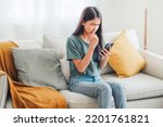 Small photo of Worried young woman looking at smartphone screen, dissatisfied with bad news message, spam or scam sms. Bad mood lifestyle concept.