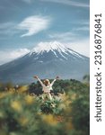 Small photo of Happy tourist traveler woman enjoying with open arms on lake kawaguchiko with mount fuji in japan, spring and summer, Japan travel vacation