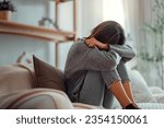 Small photo of Depressed young woman sitting on couch in the living room at home, Frustrated confused female feels unhappy problem in personal life quarrel break up with boyfriend.