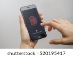 Female scanning fingerprint on smartphone, on gray background. Unlock mobile phone.
