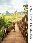 Small photo of Back view of solo traveler woman enjoying Phang Nga bay view point, walking and relaxing. Tourist at Samet Nang She, Thailand. Asia travel, trip and summer vacation concept.