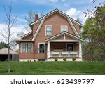 Small photo of Brown House with Gambrel Roof in Springtime