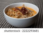 Small photo of A bowl of shamu datshi with is a dish of cheesy mushrooms.