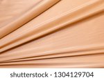 Abstract texture of natural orange, peach or apricot color fabric as concept background. Fabric texture of natural cotton or linen, silk or satin, wool or jersey textile material. Luxurious background