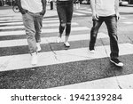 Black and white photo of people crossing the road in the city