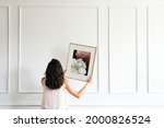 Small photo of Curator hanging floral art frame on the wall