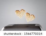 Two heart shaped toast bread roasted toasted in a toaster. Breakfast preparation on Valentine's Day. symbol sign of love. Concept  