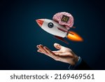 Small photo of Fast growing application of artificial intelligence (AI) concept. Brain with computer chip on itself and text AI representing artificial intelligence. Cartoon rocket holding brain flies up.