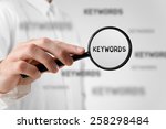 Find keywords concept. Marketing specialist looking for keywords (concept with magnifying glass). 