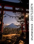 Small photo of A traditional red torii and the Fuji mountain with snow cover at sunset, beautiful landmark travel place. Winter seasons japanese landscape with a Tori gate. Mt. Fuji is Japan tallest mountain