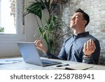 Small photo of Serene office male employee sit at desk relaxing doing yoga, practice meditation to reduce stress relief fatigue feel internal balance at workplace, improve mindfulness, maintain mental health concept