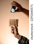 Small photo of male hand holds talcum brush and neatly pours talcum powder from a bottle on it. Barber shop tools