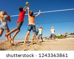 Beach volleyball players jumping to spike the ball