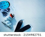 White alpine ski boot helmet and gloves in snow view from above - winter mountains vacation concept