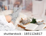 Woman lies with Cup; Kako; Hot chocolate; marshmallows; Book tray; Bed; Sofa; Blanket; Snuggle blanket; Fur; Fireplace; Wind light; Indoor; Living room; Cosy; Reading; Enjoying; Relaxing; Winter time