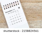 The December 2022 desk calendar on wooden background.