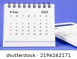 September 2023 Monthly desk calendar for 2023 year with calculator on purple background.