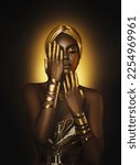 Small photo of Art Portrait closeup Beauty fantasy african woman face in gold paint. Golden metallic shiny skin hand. Fashion model girl. Arab turban. Professional glamour makeup Gold jewellery, jewelry, accessories