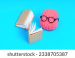 Small photo of Human brain character adorned with glasses, engrossed in reading a ledger. Creative accounting related concept.