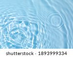 Small photo of De-focused blurred transparent blue colored clear calm water surface texture with splashes and bubbles. Trendy abstract nature background. Water waves in sunlight with copy space.