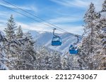 Bansko, Bulgaria winter ski resort panorama with blue gondola lift cabins, snow forest pine trees, mountain peaks view