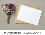 Flowers, blank paper and envelope on a table top view