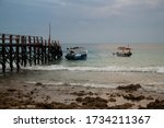 Small photo of Bali, Indonesia - August 16, 2019: Boats approaching the pier at the beach at NusaBay Menjangan by WHM