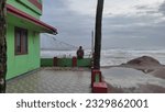 Small photo of Trivandrum, Kerala, India- July 10, 2023: hapless man sitting Infront of his house looking out at the raging sea 