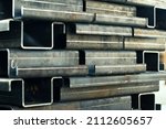 Small photo of Products are bent on a bending machine stacked in layers on a pallet in the workshop, close-up. Factory made metal parts.