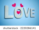 love wooden letters and heart shapes on the blue background for valentine's day