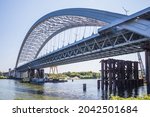 Construction of a large arched bridge in the capital of Ukraine. Podolsky bridge, panoramic view of the bridge under construction across the Dnipro, clear weather, summer. Kyiv