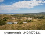 Small photo of Old closed quarry. Puddles in an old quarry. Trees growing over geological structures of hercynian orogeny inside of old closed quarry in mountains in Ukraine