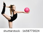 girl gymnast in black body and leggings is training with a pink gymnastic ball. children's professional sport. Rhythmic gymnastics.