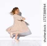Small photo of Charming little girl dressed in punk fluffy coat and sandals dancing happily with adorable smile. Childhood, style and beauty, snappy dresser, little princess. Full length portrait isolated on white.