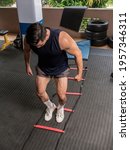 Small photo of Closeup of footwork on an agility ladder. Feet inside the square. Fitness, cardio and intense sports training concept.