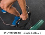 Small photo of An anonymous young man gripping a hex bar on the floor. Preparing to do deadlifts at the gym. Upper body workout.